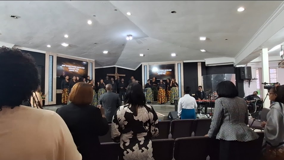 A church worship team singing on stage while the congregation stands and worships